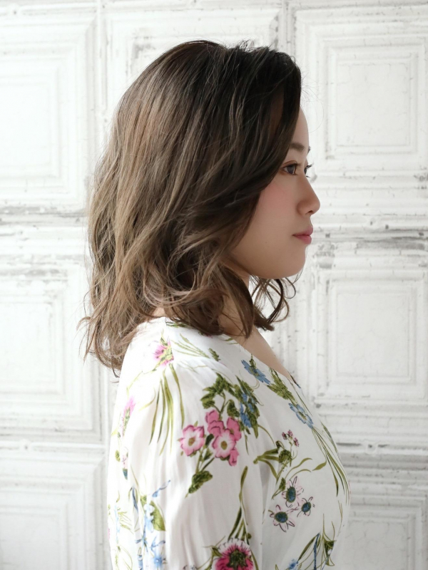 かきあげた前髪がクールなミディアムパーマスタイル