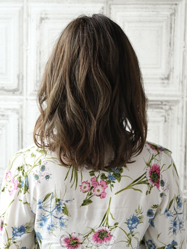 かきあげた前髪がクールなミディアムパーマスタイル