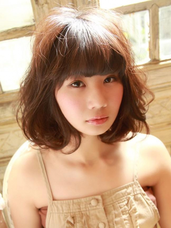 厚めバングとふわふわパーマのミディアムボブ