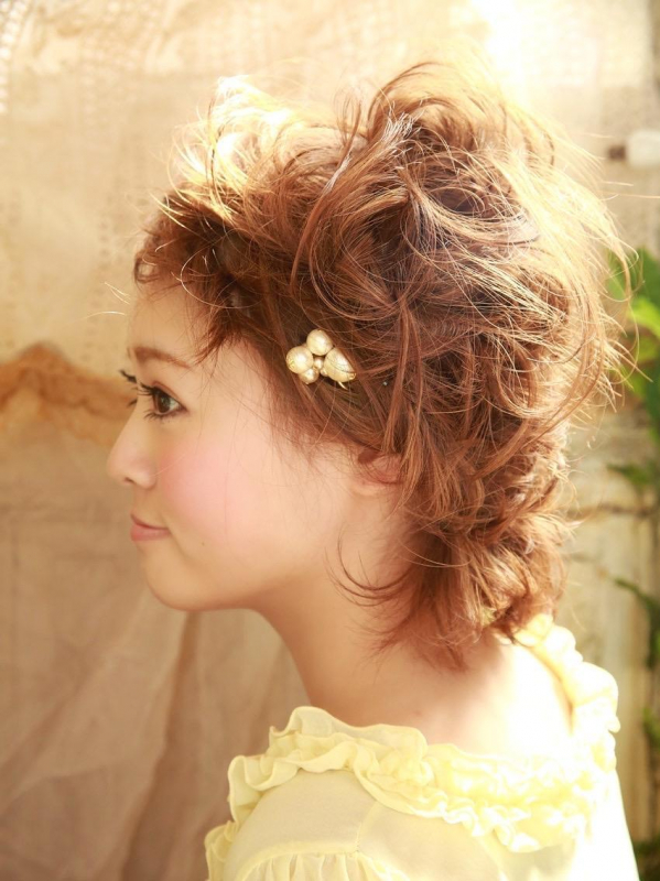 ボブスタイルの巻き髪にヘアアクセをつけたアレンジスタイル