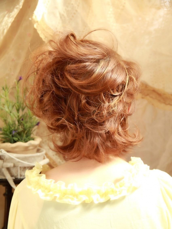 ボブスタイルの巻き髪にヘアアクセをつけたアレンジスタイル